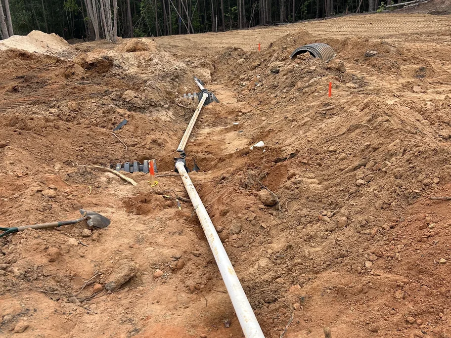 PVC septic line laid in a trench to the drain field chambers, septic system installation